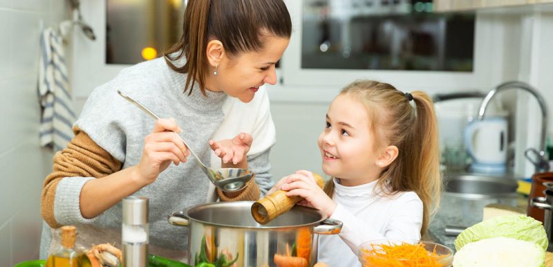 Mom and daughter making soup