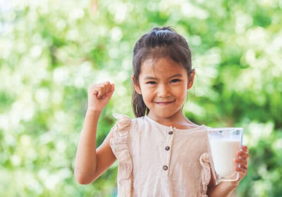 Young girl smiling with a big glass of milk