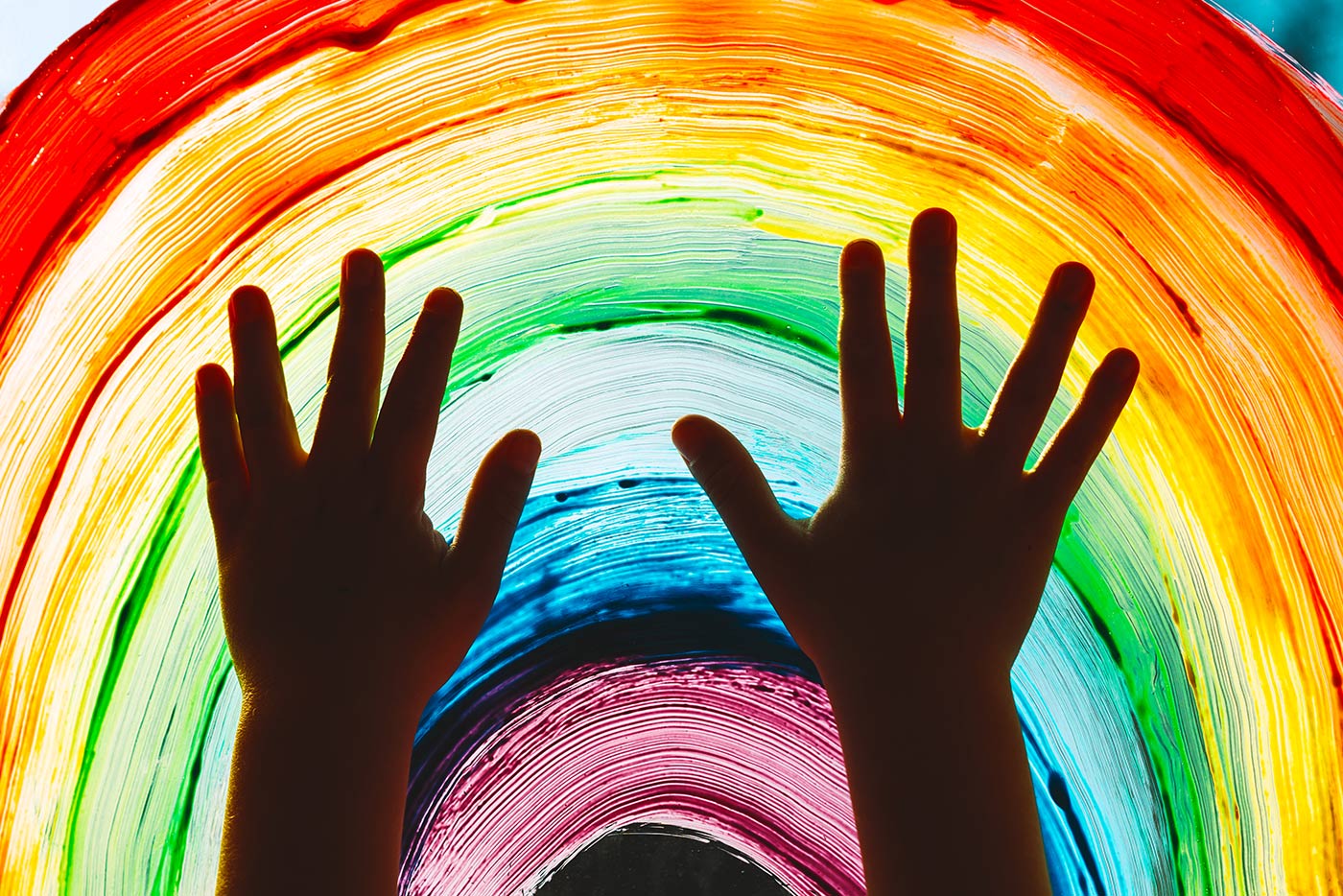 rainbow painted on glass with childs hands, Amazement Square Children's Museum in Central Virginia.