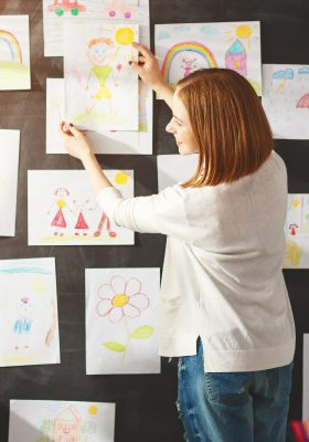 Mom hanging child's artwork on wall