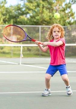 little girl playing tennis
