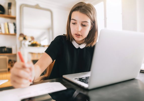 Girl with laptop doing homework