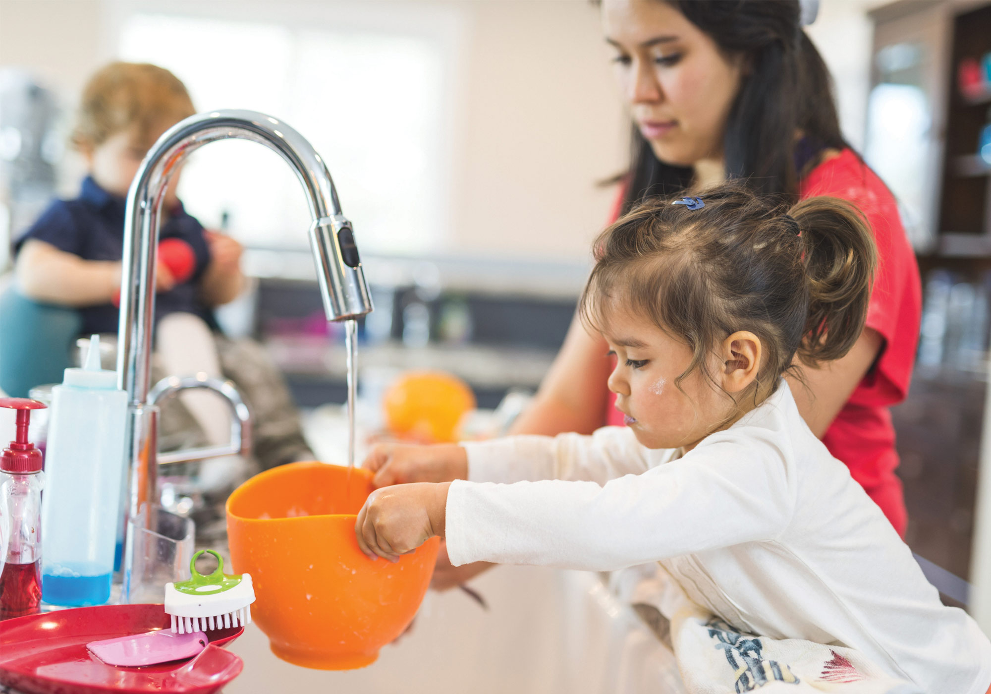 little girl helping mom in kitchen