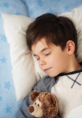 Boy sleeping with teddy bear