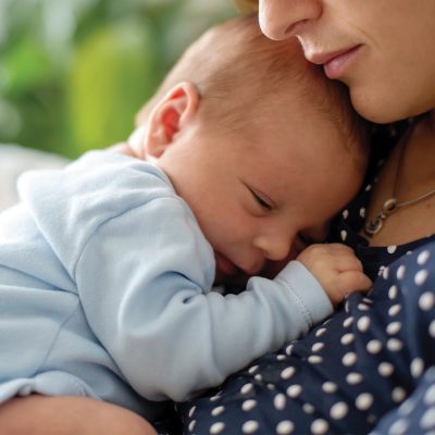 baby snuggling on his mother's chest