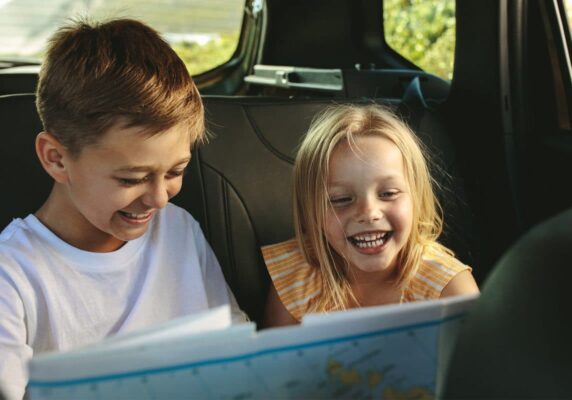 brother and sister in car looking at a map
