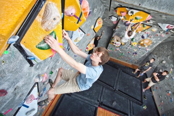 teenage boy climbing a rock wall