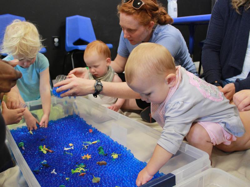 Virginia Discover Museum Baby Buds Playtime. Babies and toddlers using the touch table on Charlottesville's Historic Downtown Mall