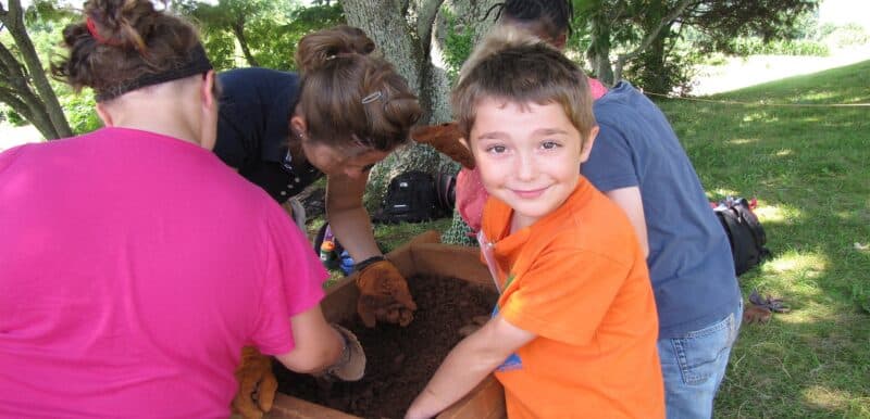campers sifting for artifacts with archaeologists