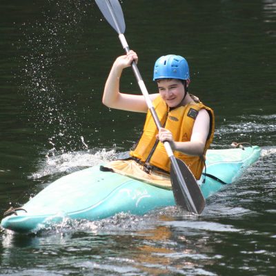 teen kayaking at summer camp friendship