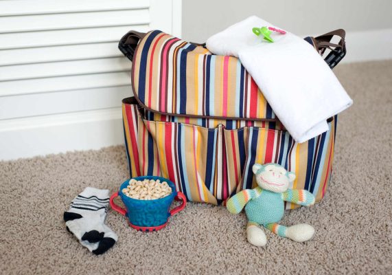 Striped diaper bag for toddler, mom supplies for being on the go with everything your child needs from snacks and diapers to toys and first aid.