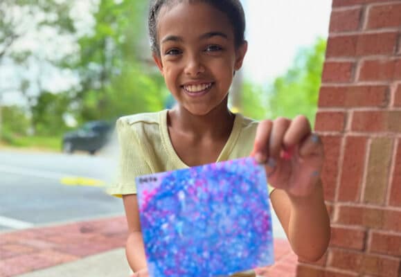 Girl with art project made at Foster art camp