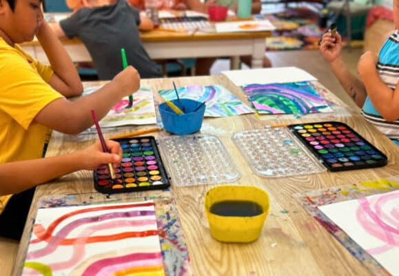 students painting with watercolors at foster art summer camp