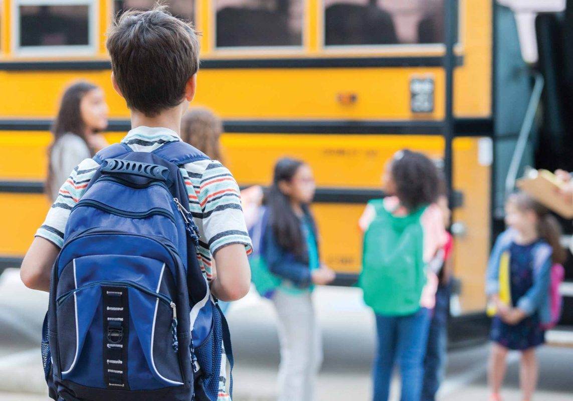 istockphoto: boy looking at school bus
