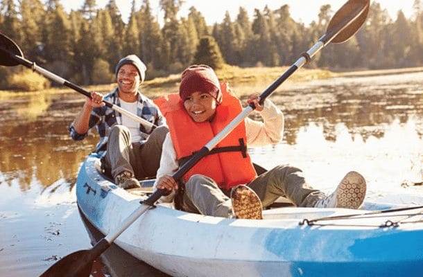 dad and son canoeing at camp in safety vests