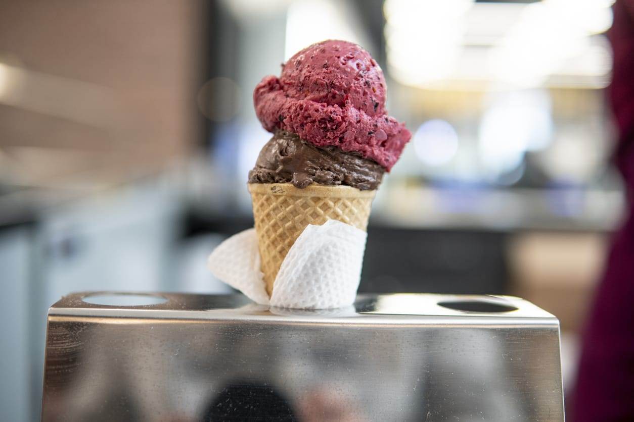 Strawberry chocolate ice cream in cone in server