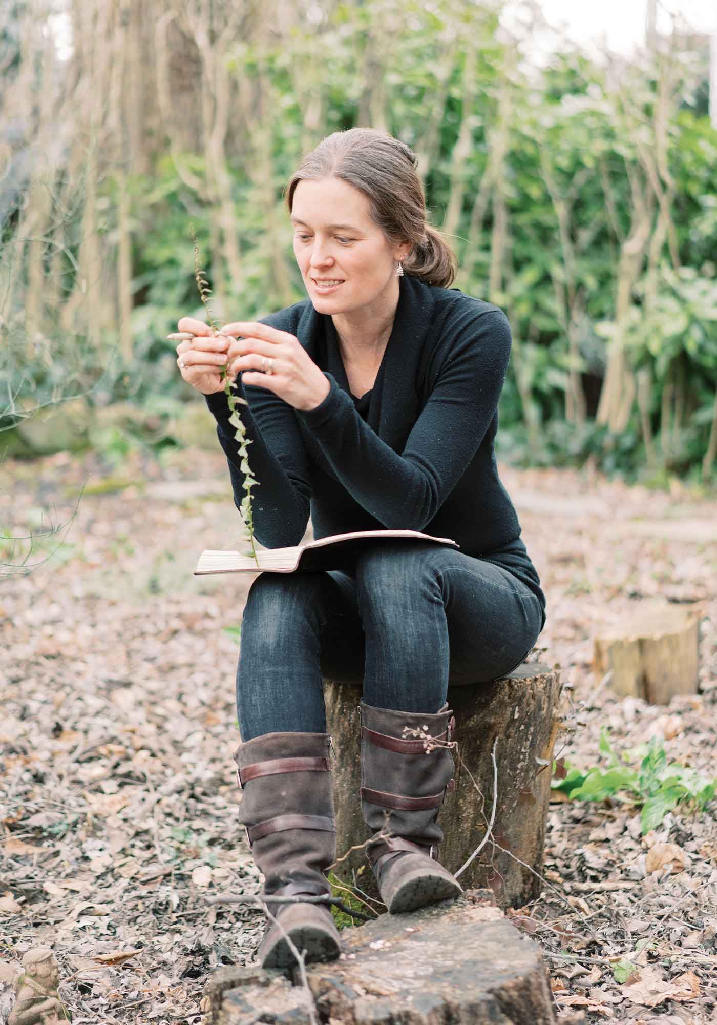 Lara Call Gastinger studying a fern frond in the garden