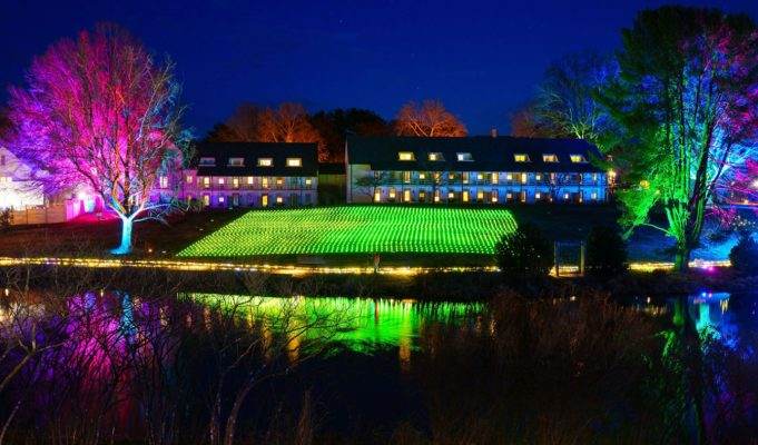 Boar's Head Inn Winter Wander Trail of Lights, lights covering the hill reflected on pond