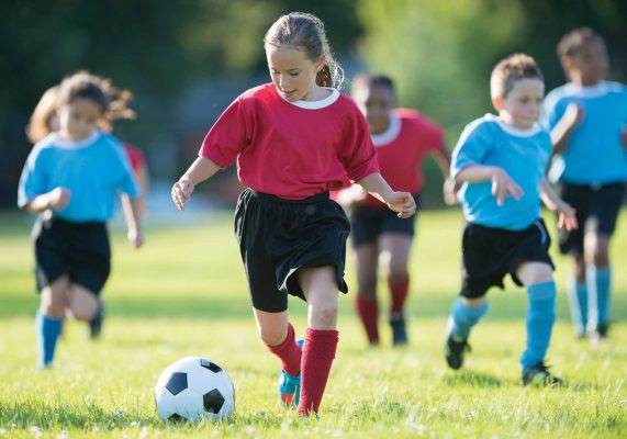 Kids playing soccer at summer camp