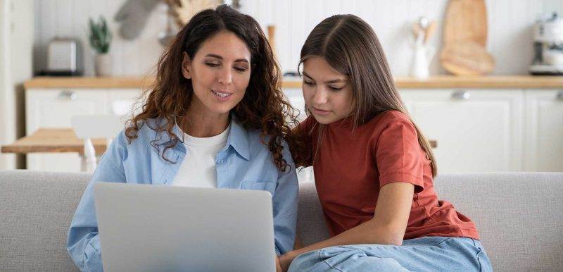 mother and daughter look at computer