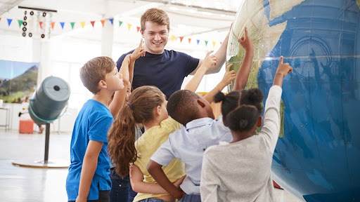 happy kids pointing on large globe