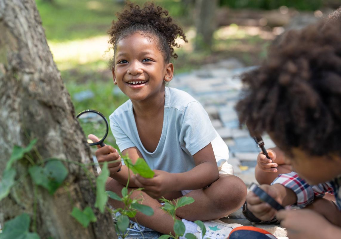 Girl with others exploring nature outdoors. istockphoto