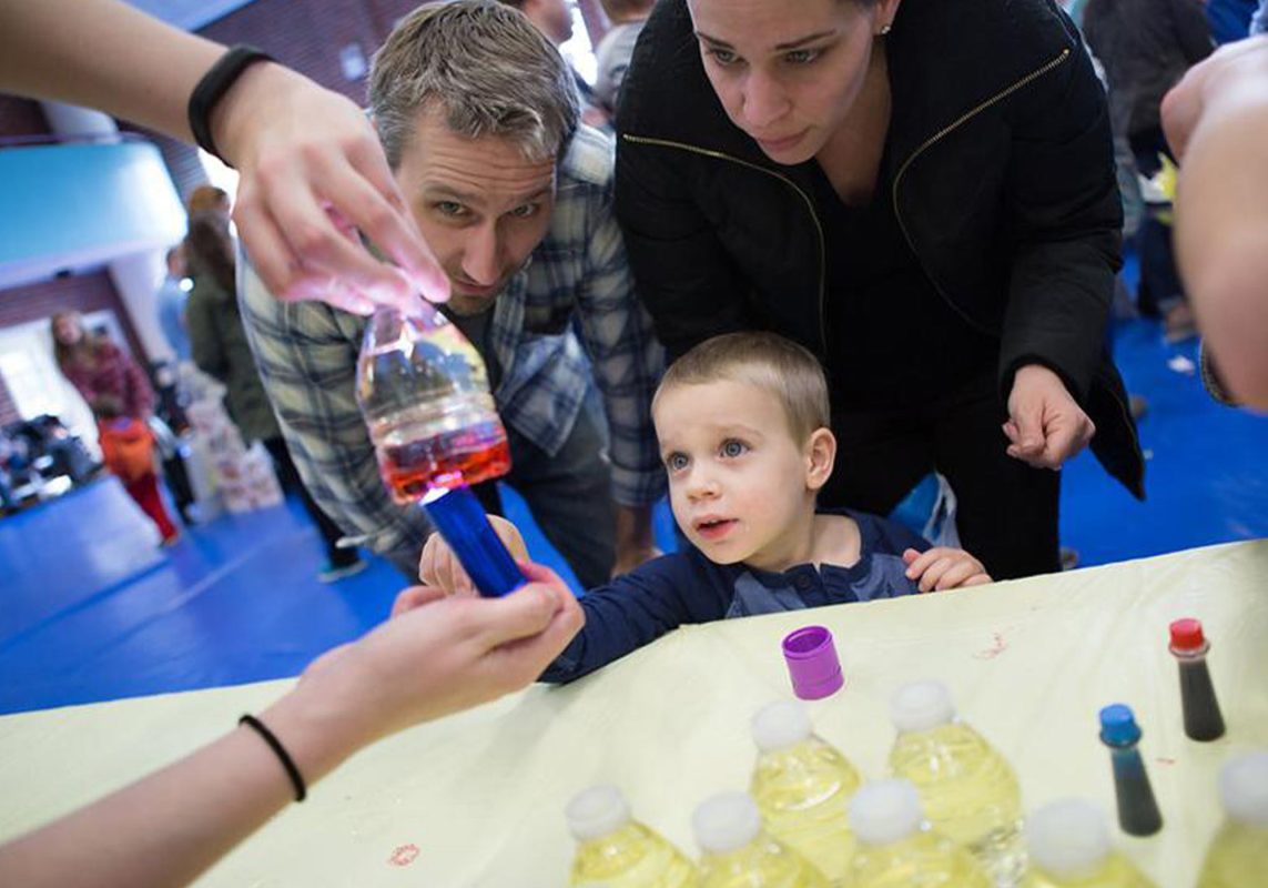 Child with parent watching one of the activities at Virginia Discovery Museum's Kid*Vention.