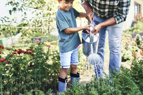 parent and child watering garden together in Central Virginia