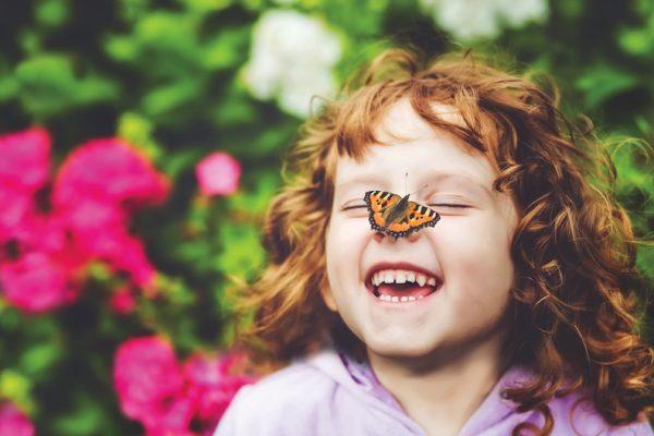 Laughing girl with a butterfly on her nose
