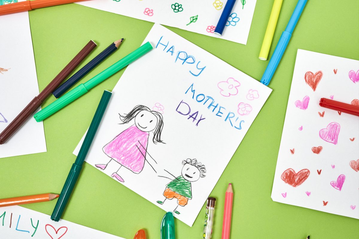 Colorful mother's day card made by child and felt tip pens lying on green table