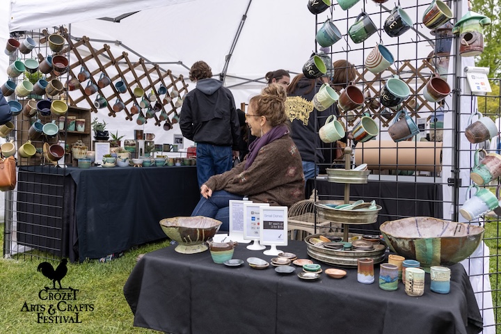 ceramic artist tend with beautiful glazed mugs and plates